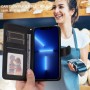Honor 600 musta suojakotelo avattuna, jossa näkyy korttipaikkoja ja puhelin, taustalla hymyilevä myyjä.