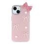 iPhone 14 kuoren koristeelliset rusetit ja pinkki rusetti viimeistelevät puhelimen ilmeen.